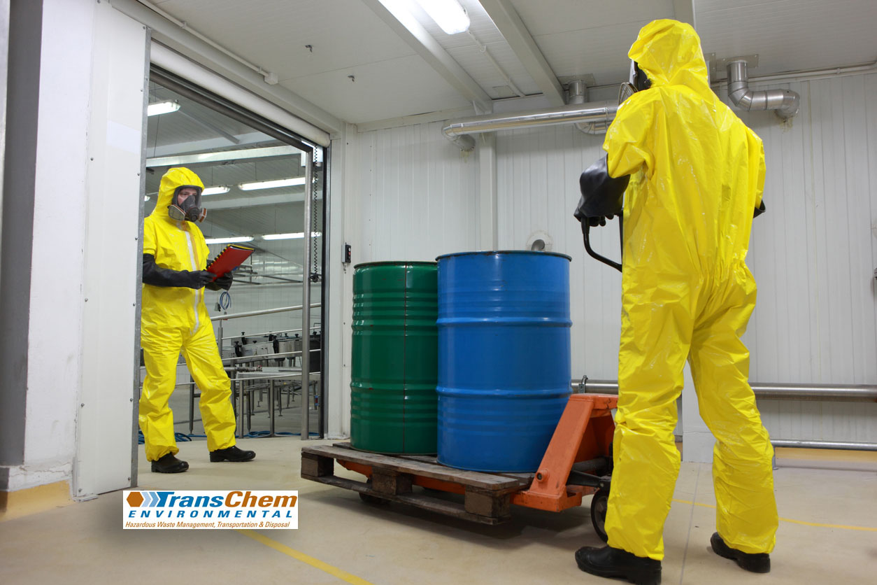 Employees in yellow HAZMAT suits conducting chemical waste disposal & removal services in Arizona.